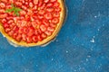 Fresh homemade strawberry shortcrust tart pie stuffed with custard vanilla cream . Sliced berries and mint leaf on the trendy