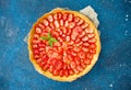 Fresh homemade strawberry shortcrust tart pie stuffed with custard vanilla cream . Sliced berries and mint leaf on the trendy