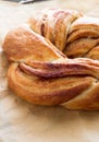 Fresh homemade sweet bun with cinnamon from yeast dough Estonian crunch. On paper for baking. Selective focus. Royalty Free Stock Photo