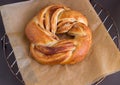 Fresh homemade sweet yeast bread swirl bun with cinnamon. On paper for baking. Selective focus. Royalty Free Stock Photo