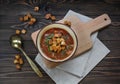 Fresh homemade tomato soup with auharics and herbs in a round plate stands on a wooden cutting board and a linen napkin. Top view Royalty Free Stock Photo