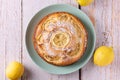 Fresh homemade vegan lemon cake served on a mint colored plate on a white rustic wooden table. Sweet dessert with citrus fruit. Royalty Free Stock Photo