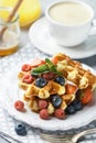 Fresh homemade waffles with raspberries, strawberries, blueberries and honey Royalty Free Stock Photo