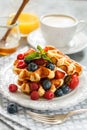 Fresh homemade waffles with raspberries, strawberries, blueberries and honey Royalty Free Stock Photo