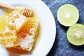 Fresh honey and lemon lime / Close up of yellow sweet honeycomb slice on white plate Royalty Free Stock Photo