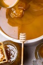 Honey in jar and big bucket, honeycomb and wooden stick, metal ladle Royalty Free Stock Photo