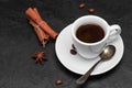 Fresh hot black coffee in white cup, coffee beans, cinnamon sticks, anise star on black background. Closeup Royalty Free Stock Photo