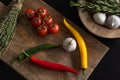 Fresh hot chili peppers lie on a wooden cutting board on a black table Royalty Free Stock Photo