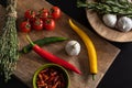 Fresh hot chili peppers lie on a wooden cutting board on a black table Royalty Free Stock Photo