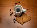 Fresh and hot espresso in white cup with coffee beans and heart shaped ginger bread around Royalty Free Stock Photo