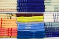 Fresh Hotel Towels Folded and Stacked on a Shelf. Colorful cotton towels neatly folded on shelf Royalty Free Stock Photo