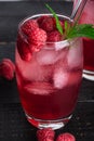 Fresh ice cold berry juice drink with mint, summer raspberry lemonade in glass with straws on dark wooden background Royalty Free Stock Photo