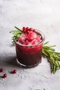 Fresh ice cold fruit cocktail in glass, refreshing summer red currant berry drink with rosemary leaf