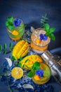 Fresh Ice mango soda drink decorate by Blue Butterfly Pea Flower and mint on the wood table there are mango slice, ice, lemon, Royalty Free Stock Photo