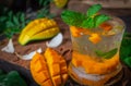 Fresh Ice mango soda drink on the wood table there are mango slice and leaves place around