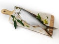 Fresh Indo-Pacific tarpon fish decorated with herbs and vegetables on a wooden pad,Selective focus.White background Royalty Free Stock Photo