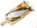 Fresh Indo-Pacific tarpon fish decorated with herbs and vegetables on a wooden pad,Selective focus.White background Royalty Free Stock Photo