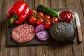 Fresh ingredients for beef black burger on black stone board. Delicious food. Homemade cooking Royalty Free Stock Photo