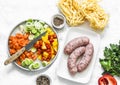 Fresh ingredients for mediterranean style lunch - turkey sausages, fettuccine pasta, chopped bell peppers, carrots, leeks on a