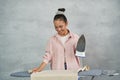 Fresh and ironed. Attractive young woman smiling while ironing clothes on ironing board at home Royalty Free Stock Photo