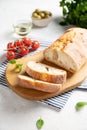 Fresh italian ciabatta bread cut  slices with tomato, basil and olive on white background. Close up image Royalty Free Stock Photo