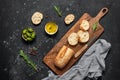 Fresh Italian ciabatta bread in slices with olive oil, olives and rosemary on a black stone background. Top view, flat lay Royalty Free Stock Photo