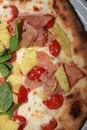 Fresh italian Pizza with Ham, Pineapple, Tomato, Basil and Cheese Royalty Free Stock Photo