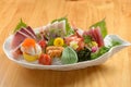 Fresh Japanese food mixed Sashimi Moriawase platter with ice, fish slice a dish isolated on wooden background top