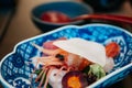 Fresh Japanese sashimi, raw Botan Ebi shrimps and wasabi in indego colored bowl. Close up shot