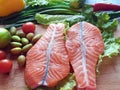 Fresh Fish Raw Salmon Two steaks with ingredients vegetables and spices tomatoes lemon and olives cucumber green salat onion g Royalty Free Stock Photo