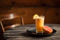 Fresh juice with red orange on the plate at wooden table