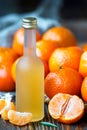 Fresh juice of ripe mandarins or tangerine liquor in a small bottle, selective focus