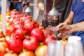 A fresh juice seller on the street squeezes juice from a pomegranate Royalty Free Stock Photo
