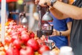 A fresh juice seller on the street squeezes juice from a pomegranate Royalty Free Stock Photo