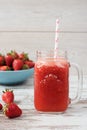 Fresh juice, shake, milkshake of strawberries in a mason jar with a straw. Pile of juicy ripe organic fresh strawberries in a Royalty Free Stock Photo