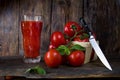 Fresh juice from tomatoes. Basket with tomatoes and a kitchen knife Royalty Free Stock Photo