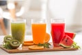 Fresh juices smoothie three glass red green orange tropical fruits water melon, kiwi, orange. Selective focus Royalty Free Stock Photo