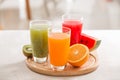 Fresh juices smoothie three glass red green orange tropical fruits water melon, kiwi, orange. Selective focus Royalty Free Stock Photo