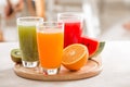 Fresh juices smoothie three glass red green orange tropical fruits water melon, kiwi, orange. Selective focus Royalty Free Stock Photo