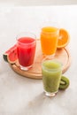 Fresh juices smoothie three glass red green orange tropical fruits water melon, kiwi, orange. Selective focus Royalty Free Stock Photo