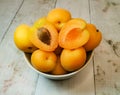 Fresh juicy apricots in a deep plate on a light wooden tabletop Royalty Free Stock Photo