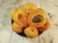 Fresh juicy apricots in a deep plate on a light wooden tabletop Royalty Free Stock Photo