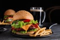 Fresh juicy bacon burger and fries on grey table Royalty Free Stock Photo