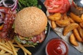 Fresh juicy bacon burger and fries on grey table Royalty Free Stock Photo