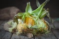 Fresh juicy corn with leaves on a wooden table. Autumn background. Selective focus.