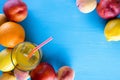 Fresh juicy fruit and cold juice on blue wooden table