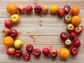 Fresh juicy fruits: red apples on a wooden background, oranges, lemons on a light wooden background. Green diet vegetarian Royalty Free Stock Photo