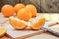 Fresh and juicy half and slice of orange fruit on a chopping block on weathered wooden table background. Royalty Free Stock Photo