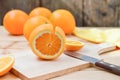 Fresh and juicy half and slice of orange fruit on a chopping block on weathered wooden table background. Royalty Free Stock Photo