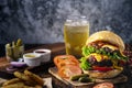 Fresh and juicy hamburger. Cheese burger with beef or bacon, patty tomato, onion ring and sparkling water or beer Royalty Free Stock Photo